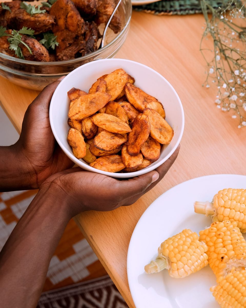 Repas africain avec plantain, maïs et viande grillée